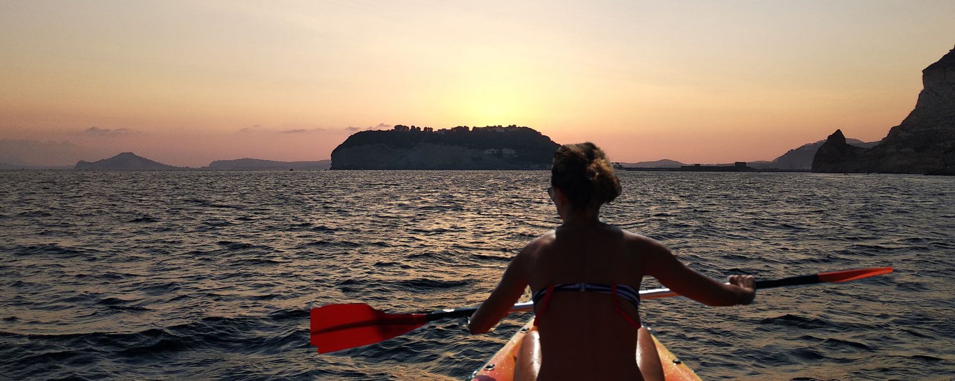 Ragazza in kayak che rema verso il tramonto: Posillipo