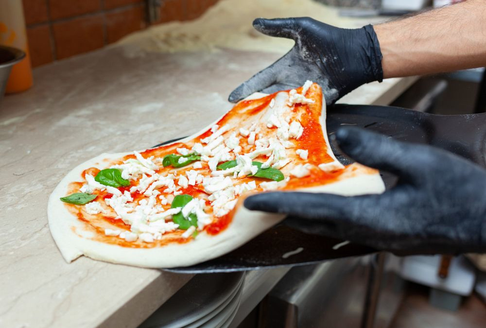 Margherita pizza put on baking shovel for cooking.
