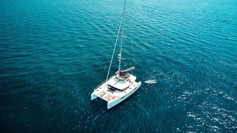 Aerial drone top view photo of luxury yacht with white rubber boat. Capri island.