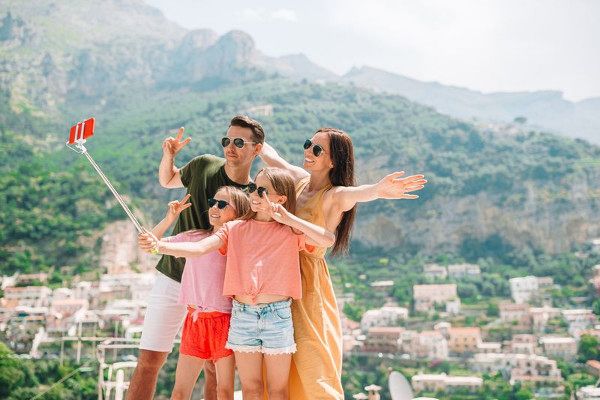 Family vacation in Europe. Family of four taking selfie photo background Positano on Amalfi coast